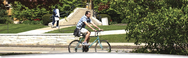 Photo of student riding bike on campus