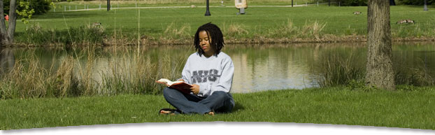 Photo of student reading by lagoon