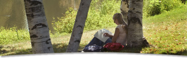 Photo of student studying by the lagoon
