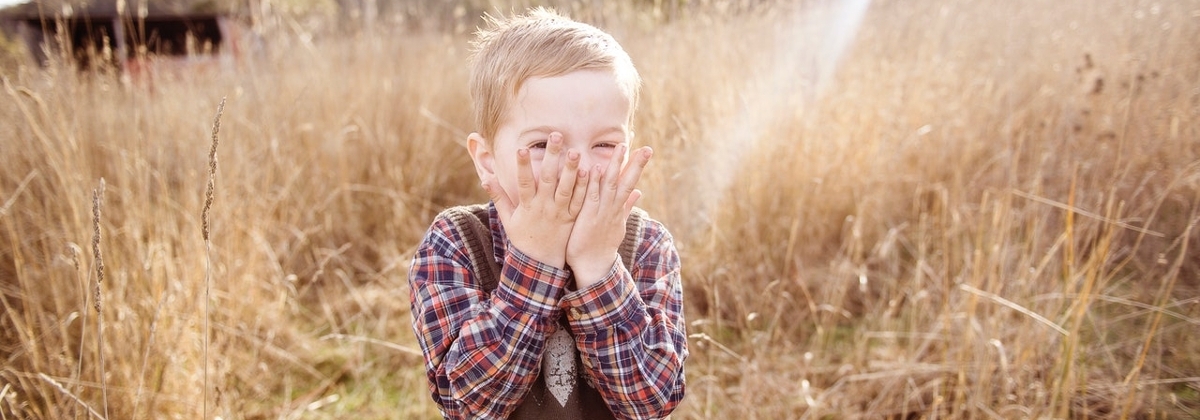 Child covering his face with hands
