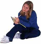 female student sitting on the floor taking notes