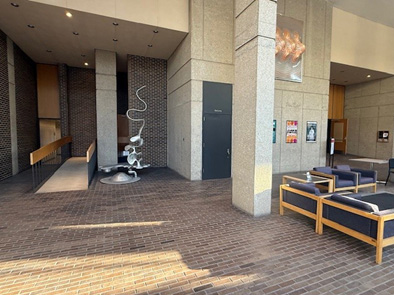 The lobby of Boutell music hall depicting a slightly sloping floor and an accessible ramp entrance on the left