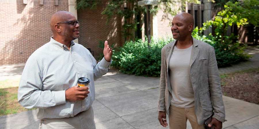 Two faculty members, outside talking.