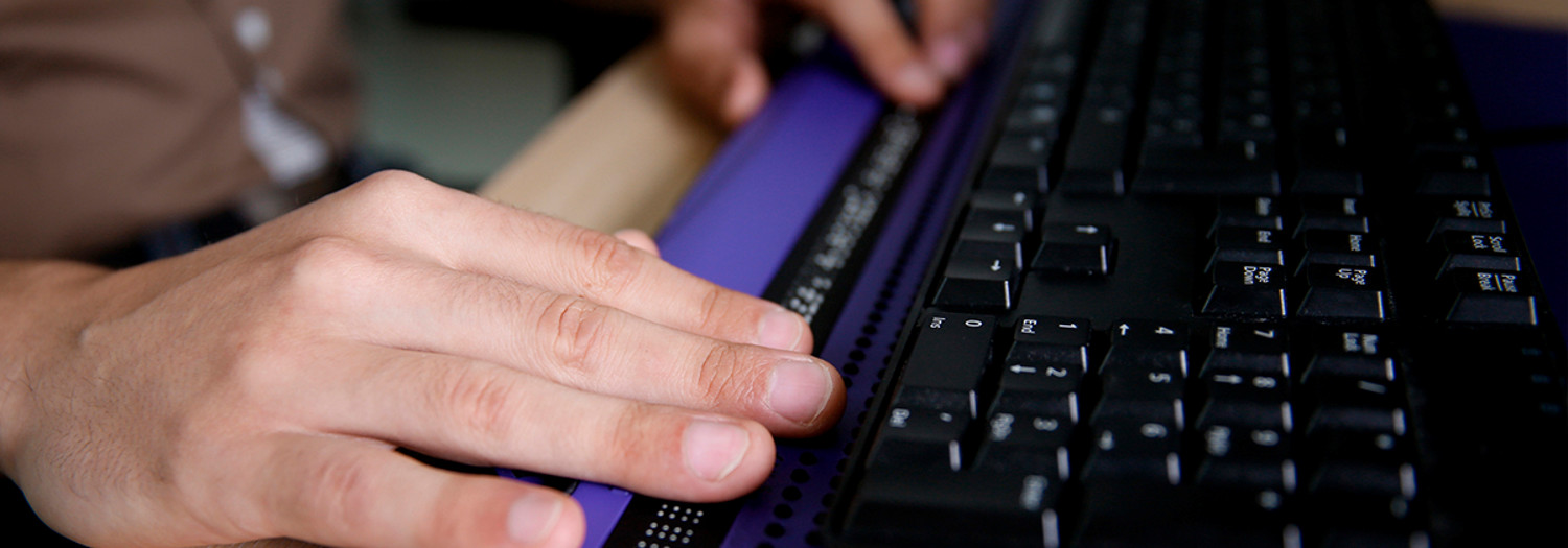 A person using a computer a refreshable braille display