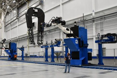 An ultrasonic-equipped robot arm inspects aerospace structures at Spirit AeroSystems
