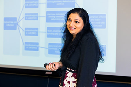 professor standing in front of classroom holding clicker