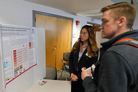 two students view presentation display at Student Research Symposium