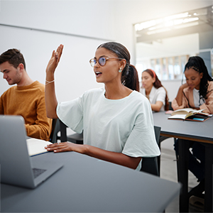 Young woman in classroom, asking with hand up while classmate listen