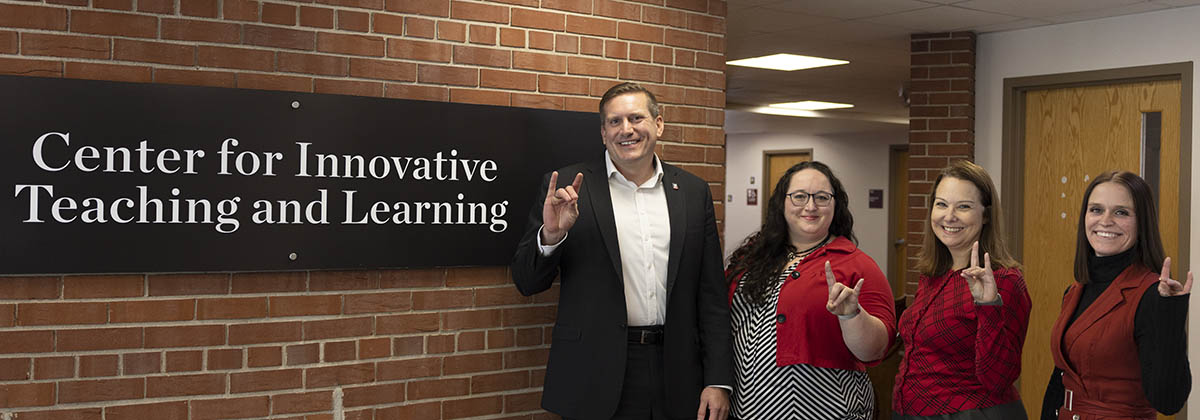 CITL leadership standing in front of sign