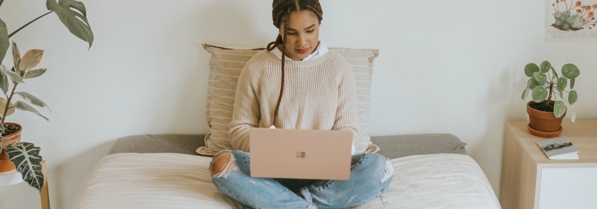 woman sitting on sofa at home and using a laptop
