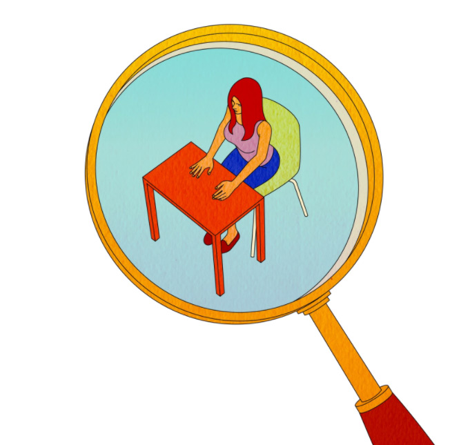 student sitting at desk as seen through magnifying class