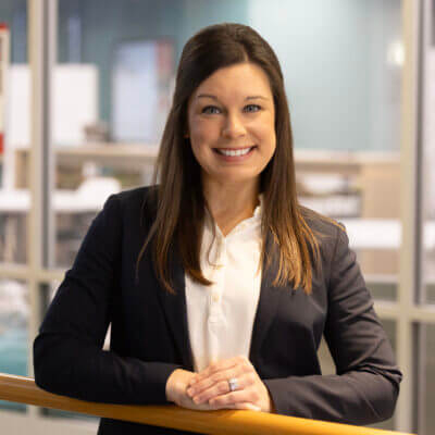 portrait of Candice Hux standing with hands folded on a railing