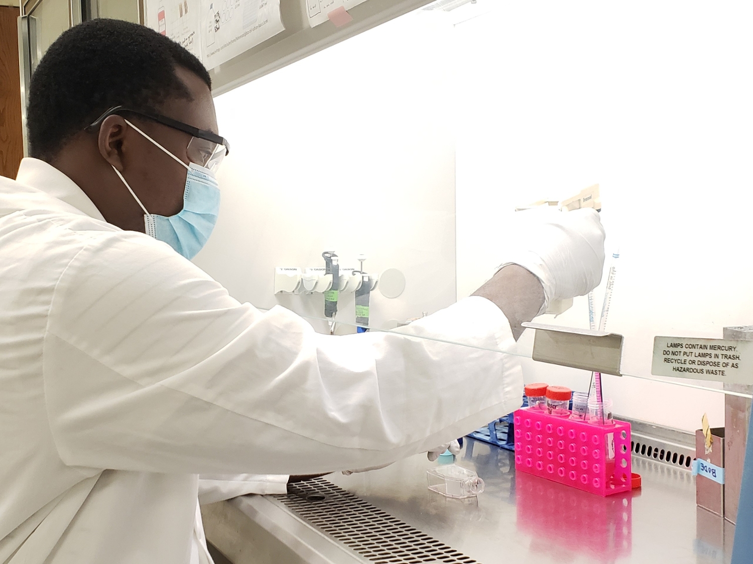 George Babatunde Olawuni adds growth medium to a human hepatocellular carcinoma cell line in the laminar flow hood.