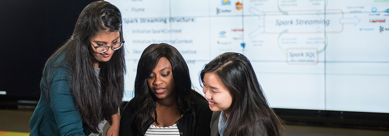 Three computer science students meet to discuss a project