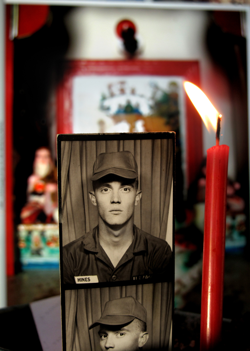 Old photo booth portrait of a soldier beside a lit red candle