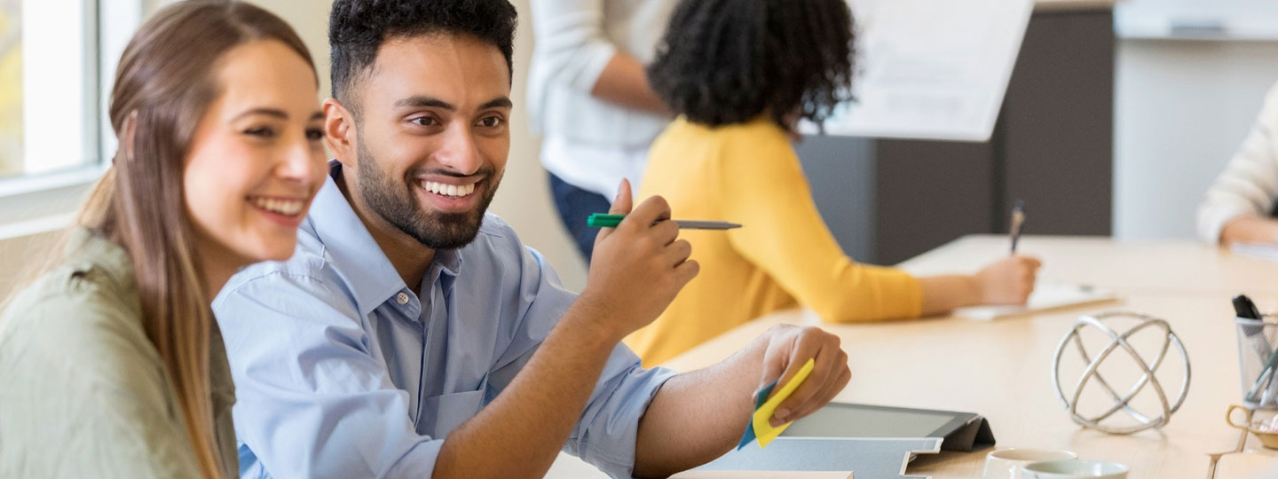 Smiling man and woman at a conference 