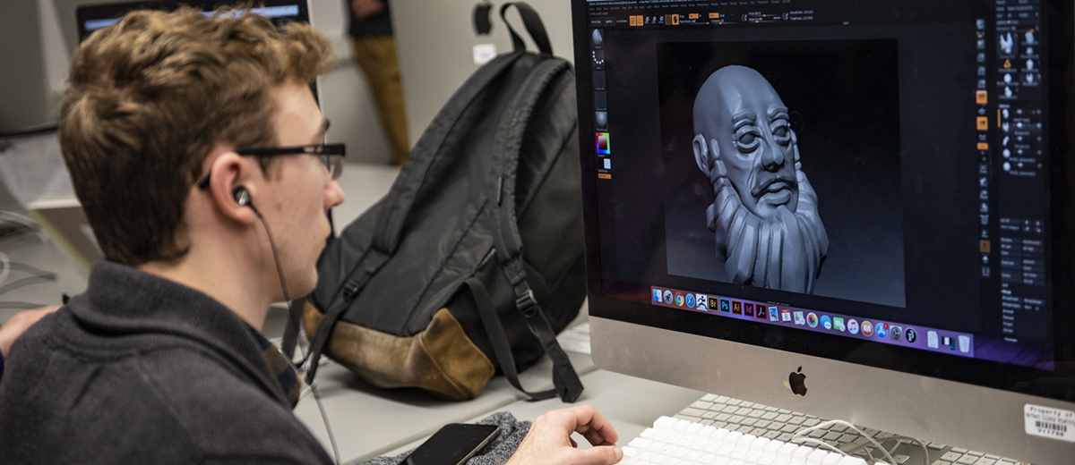 Student creating digital character design on an apple computer.