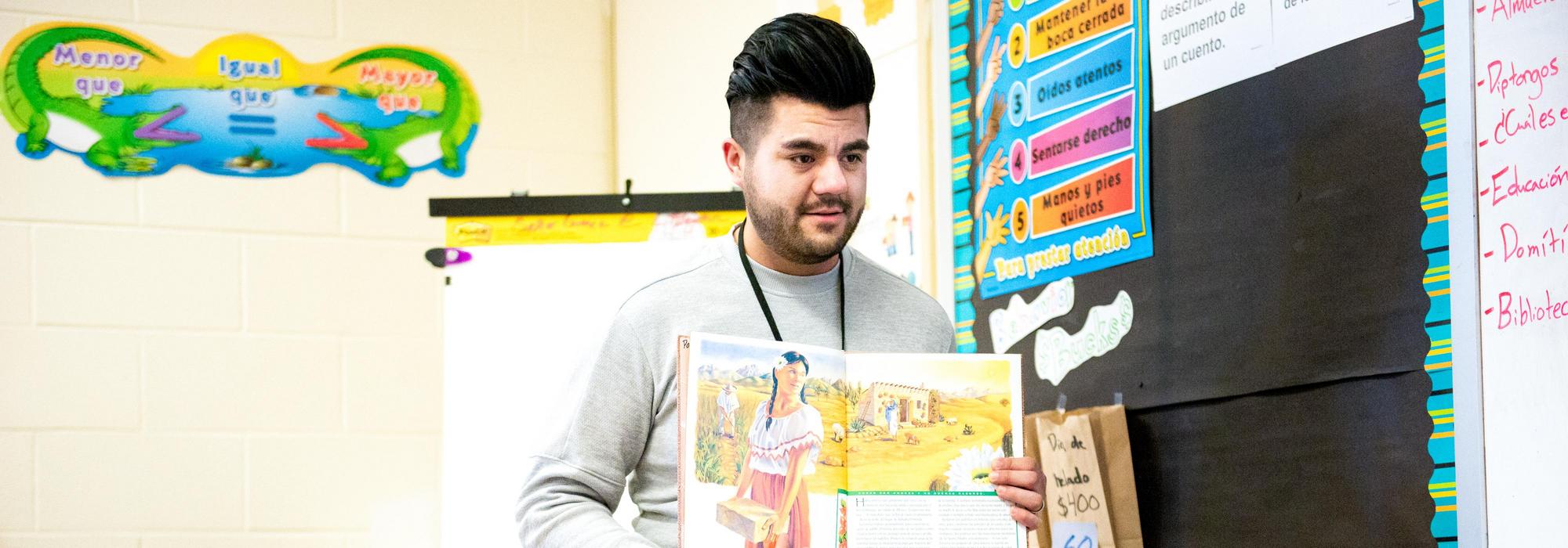 Student teacher standing behind students with model of aorta.