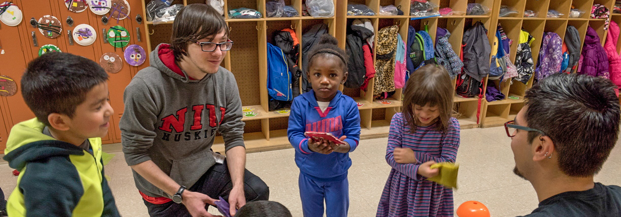 Student teachers playing with children in classroom