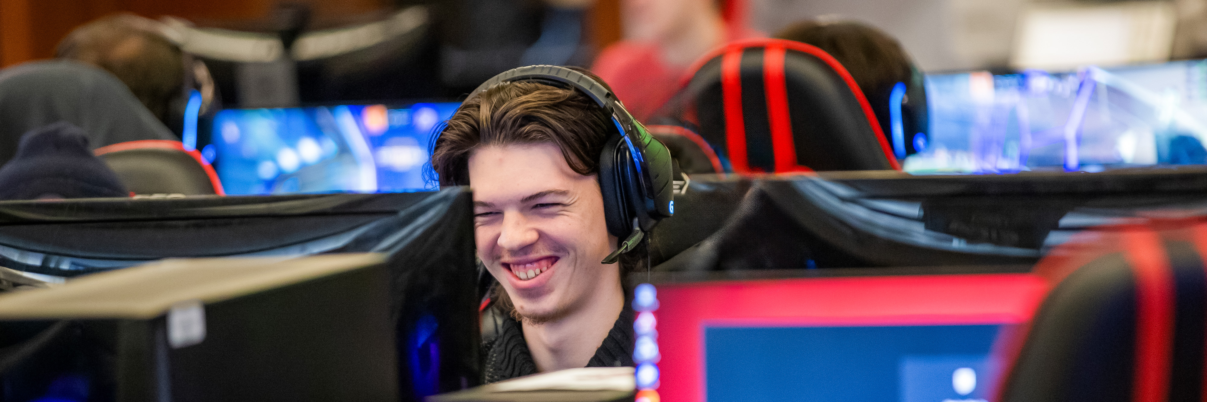 Smiling student playing games in the Esports Arena.