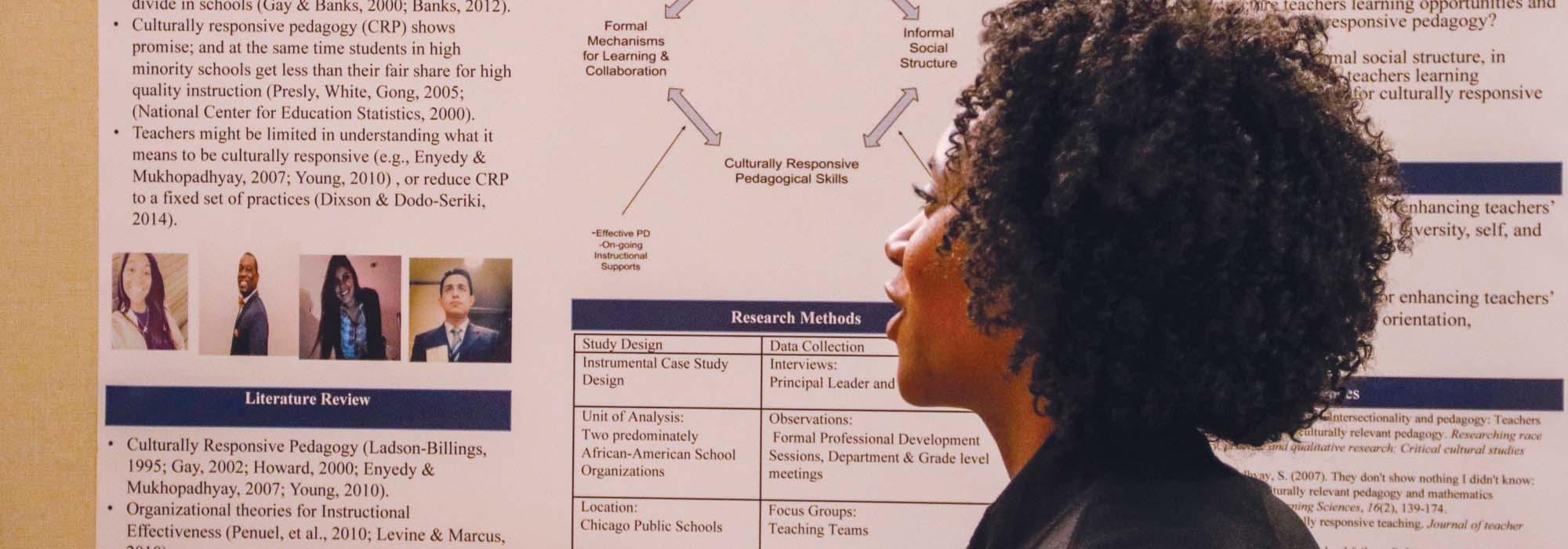 A student discusses research contained on a conference poster.
