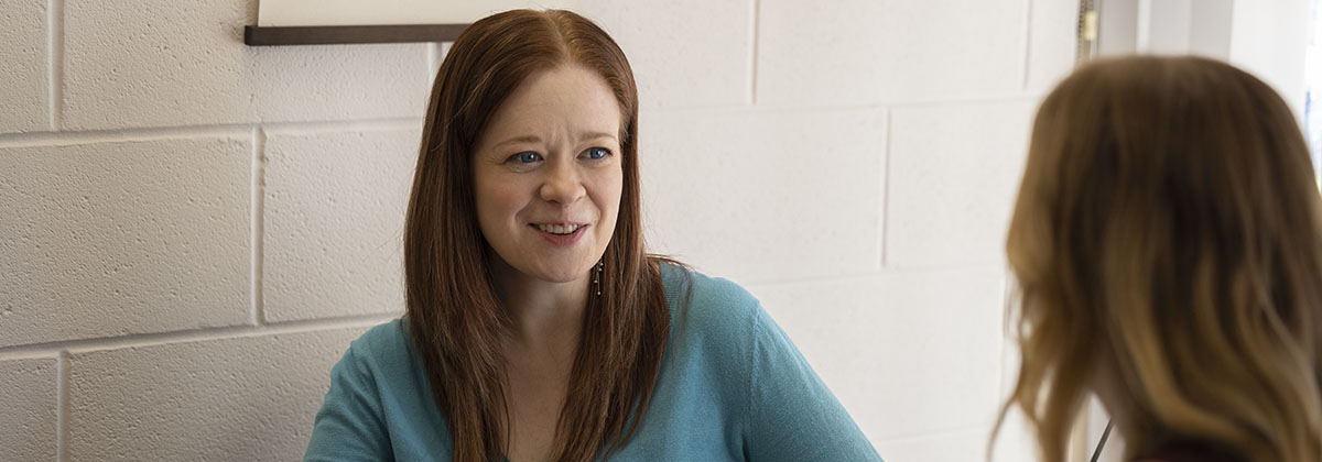 two individuals sitting at a table discussing