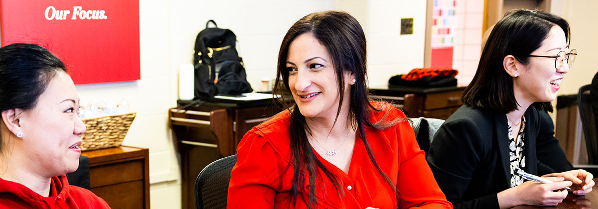 three faculty sitting at a conference table discussing