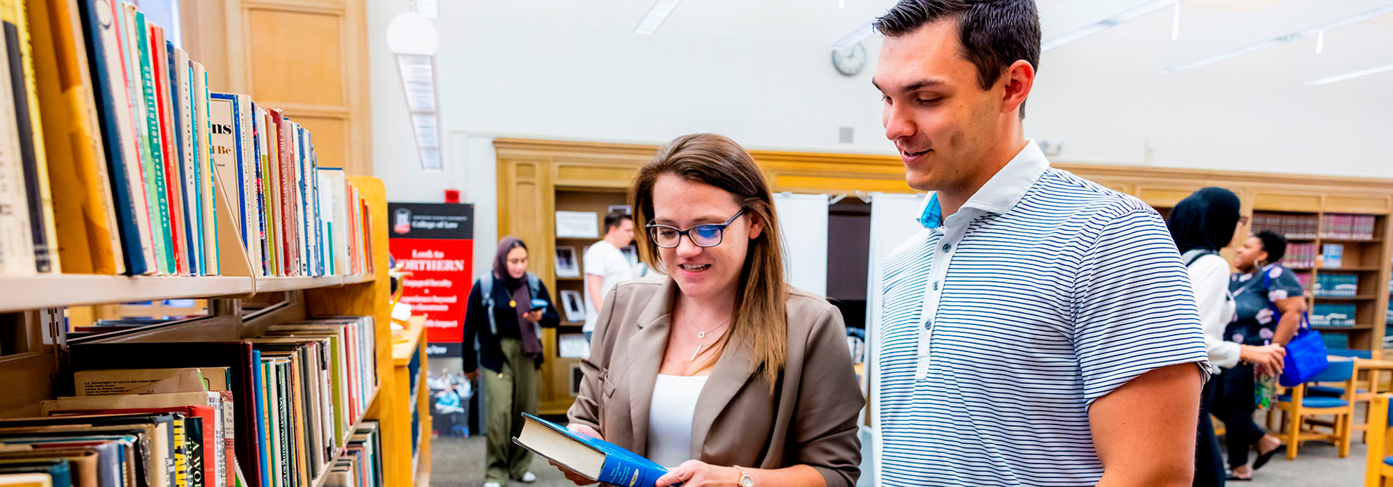 Students looking at a book in the Law Library