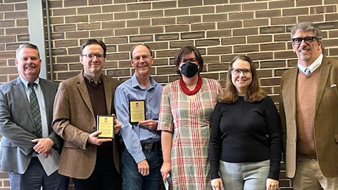 CLAS faculty and staff receiving award plaques from members of Course Materials Affordability Task Force