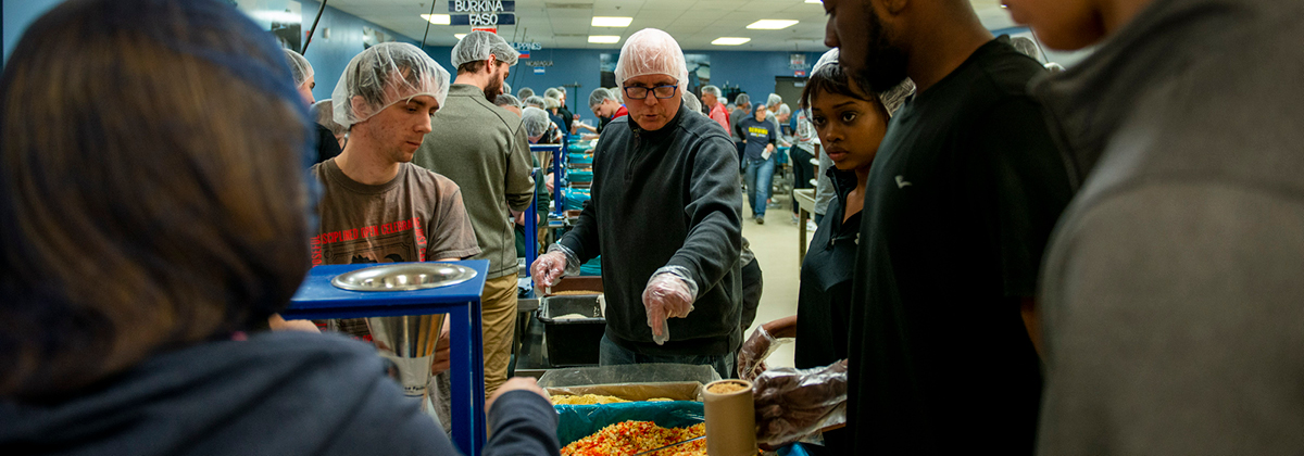 Presidential Engagement and Partnerships Professor of Philosophy Myron Engel and his students pack food for Feed My Starving Children as part of a Philosophy of Food course.