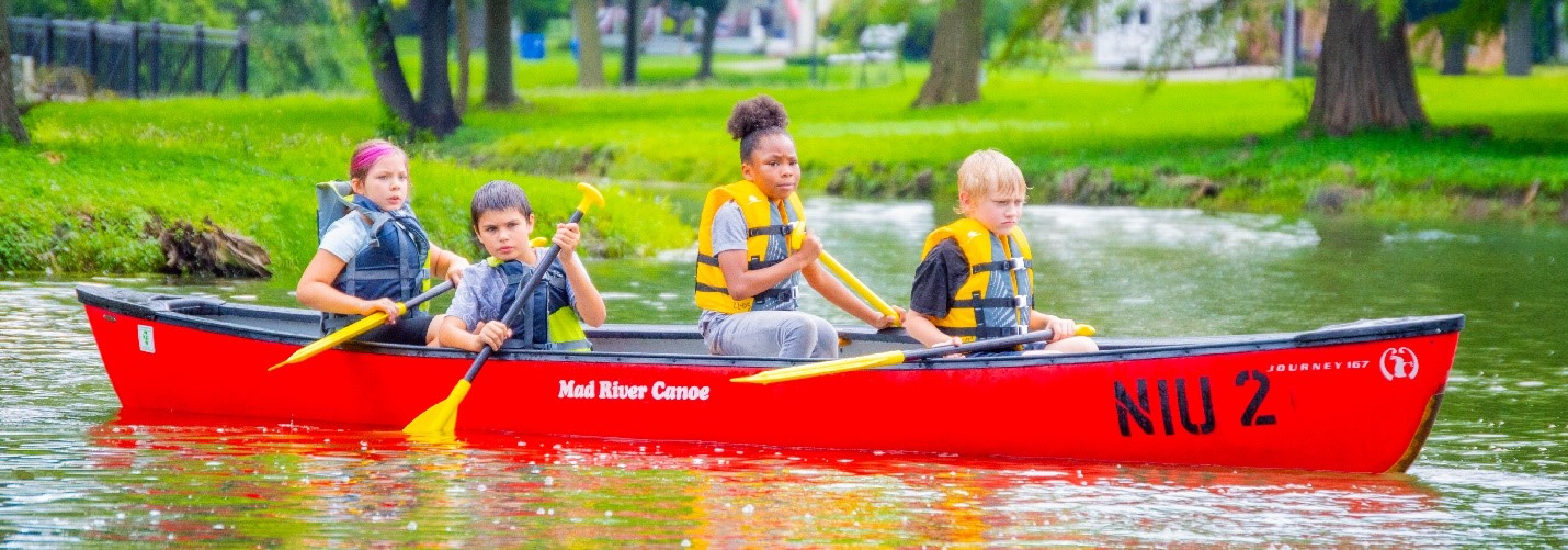Four children canoeing on the NIU Lagoon