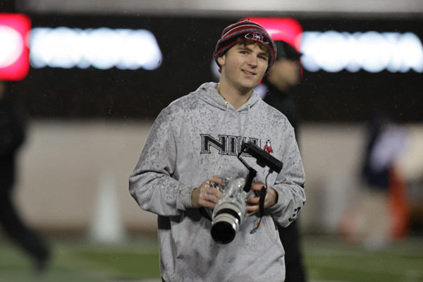 Jimmy Doles taking photos on Brigham Field at Huskie Stadium