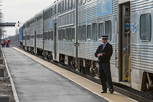 A Metra employee awaits passengers to board train at Elburn Metra station.
